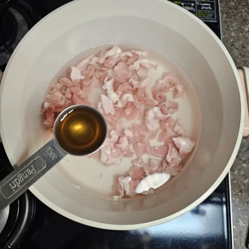 キムチチゲレシピ　豚肉、水、チャムチ液を入れる画像